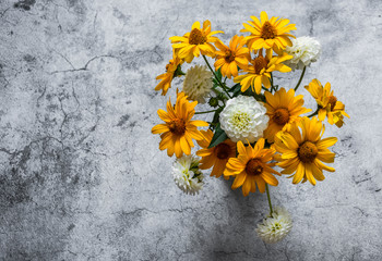 Autumn flowers yellow and white dahlias bouquet  on a gray background, top view. Copy space