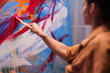 © DC Studio - Woman artist holding paint brush on large canvas in art studio. Modern artwork paint on canvas, creative, contemporary and successful fine art artist drawing masterpiece
