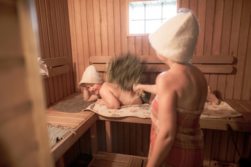 Mom with her son are soaring in a wooden bath