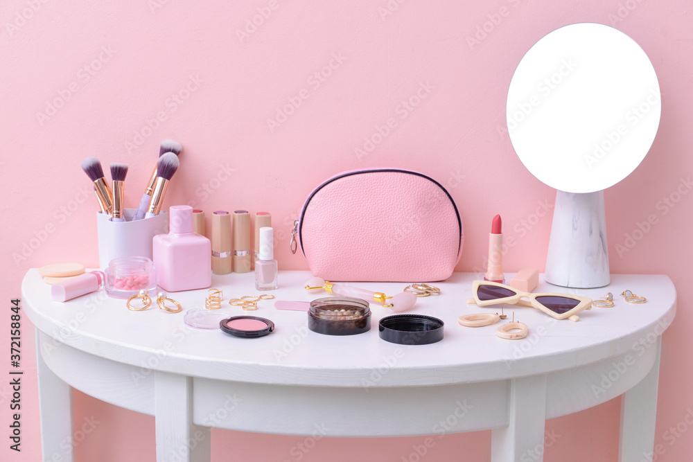 Set of decorative cosmetics with jewelry on dressing table
