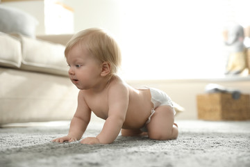 Wall Mural - Cute little baby in diaper on carpet at home