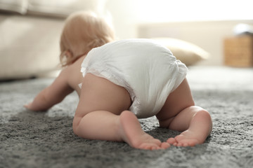 Wall Mural - Cute little baby in diaper at home, focus on legs