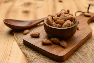 Wall Mural - Almonds In Bowl on wood table background with copy space.