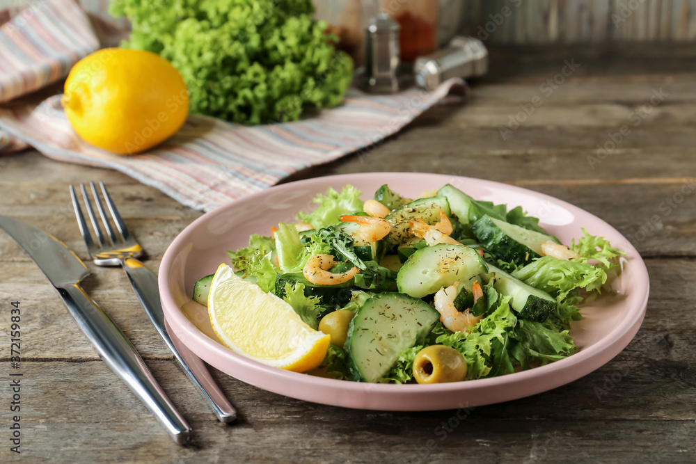 Plate with tasty cucumber salad on table