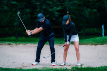 Golf Sand Bunker Playing Technique. Young Woman Practicing Bunker Shots With Golf Instructor