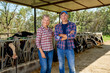 © JENOCHE - Family of farmers on rural farm with dairy cow.