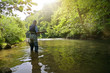 © goodluz - fly fisherman in summer fishing in a mountain river with waders and a cap