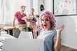 © LIGHTFIELD STUDIOS - Selective focus of excited businesswoman looking at camera while working in white office