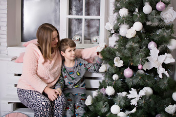 Wall Mural - mother and son decorating christmas tree. mother and son. mother and son playing. mother and son near the christmas tree