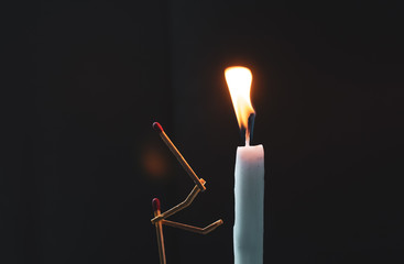 Wall Mural - Matchsticks in form of a man lighting a candle, matchstick man lighting a candle.