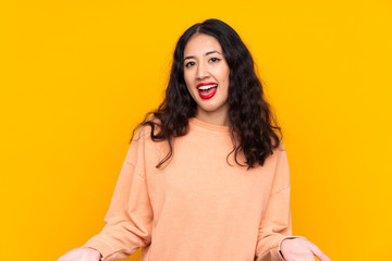 Wall Mural - Spanish Chinese woman over isolated yellow background smiling