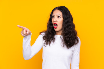 Sticker - Mixed race woman over isolated yellow background pointing away