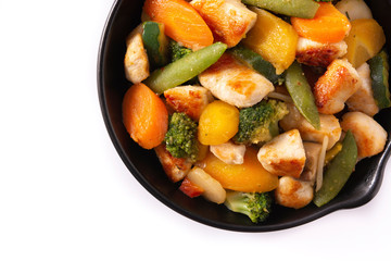 Wall Mural - Stir fry chicken with vegetables on iron pan isolated on white background. Top view. Copy space