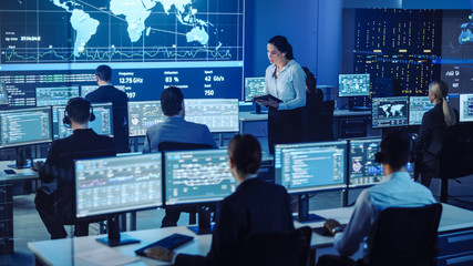 Leinwandbilder - Female Project Leader with Tablet Computer Asks Male Data Science Engineer and Checks Up on His Work Progress. Telecommunications Control Monitoring Room with a Global Map on Big Screen.