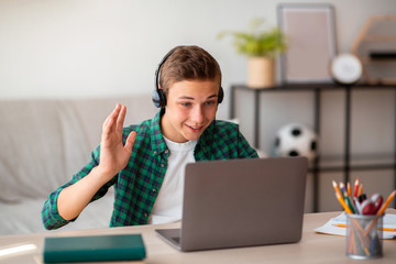 Positive teenager having video conference with teacher