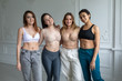 © kalinichenkod - Four happy diverse ethnicity pretty young girls women friends lying in circle look at camera together, sleepover party and multiethnic friendship concept, top view portrait