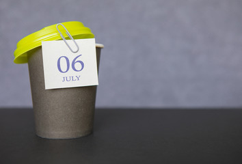 Coffee paper cup with calendar dates for July 06, Summer season. Time for relaxing breaks and vacations.