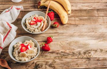 Poster - Quinoa porridge with coconut milk and fresh strawberries on wooden rustic background. Healthy Lactose and Gluten Free Breakfast.