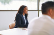 © Flamingo Images - Smiling African American businesswoman sitting in a boardroom me