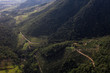 © EZ PHOTOS - Aerial view of a road serpentine going up the highlands surrounded by tropical rain forest vegetation. Road leads to coffee farm in Brazil. Coffee production fair trade storytelling concept.