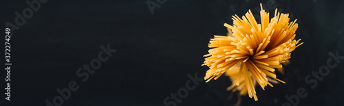 Cuadros en Lienzo top view of raw Italian spaghetti isolated on black, panoramic shot