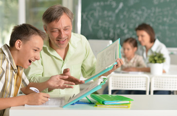 Poster - Father helping his son doing homework in classroom