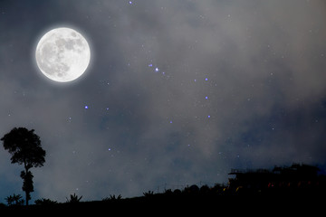 Wall Mural - Full moon in starry night over village.