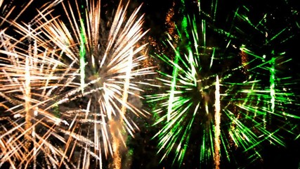 Wall Mural - fireworks exploding in green, gold, orange colors