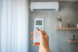 © Dragana Gordic - Hand hold remote control directed on the air conditioner. Woman hand using remote control open air conditioning 25 degrees. Open air 25 degrees, is temperature, save energy