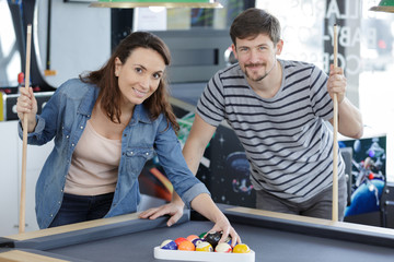 a happy couple playing billard