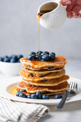 Wall Mural - Syrup pouring on pancakes. Pancakes with blueberries and sweet syrup