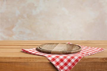 Wall Mural - Wooden cutting board and tablecloth on wooden table