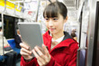 © Paylessimages - 電車でタブレットPCを見る女性