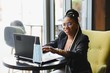 © Serhii - Focused female office worker using computer in coffee shop. African American business woman working on laptop in cafe and looking away. Internet technology concept