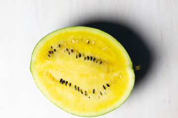 Wall Mural - yellow watermelon on a white wooden background