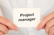 © Sinfebeth - Man's hands take a card with words project manager, finance and business concept.