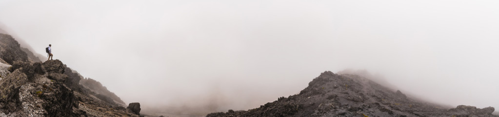 Panoramic view of man on the top of a mountain.