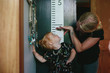 © Maria Manco/Stocksy - mother measures daughters height on wall growth chart