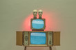 © Igor Madjinca/Stocksy - light experiment with retro TVs and doll heads