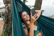 © MIHAJLO CKOVRIC/Stocksy - Woman relaxing in a hammock at the beach
