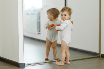 a small child cleans the house. The girl washes the mirror. restoring order in the apartment