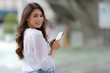 © Naypong Studio - Portrait of young woman with smiley face using a phone walks in a city