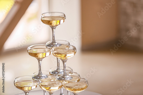 Tower made of glasses with champagne indoors