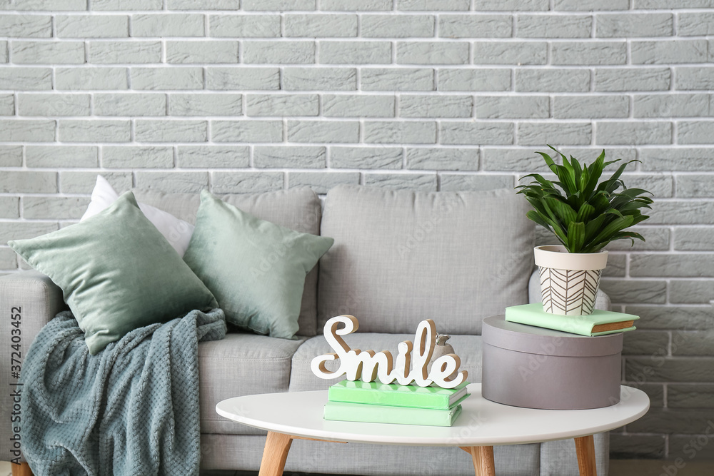 Stylish interior of living room with comfortable sofa and table