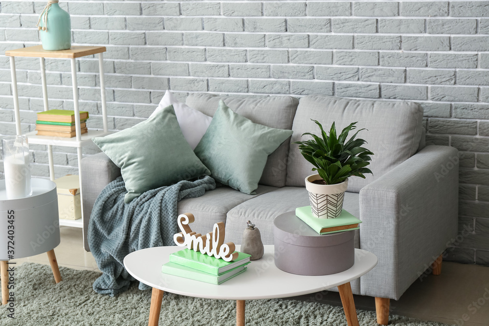 Stylish interior of living room with comfortable sofa and table