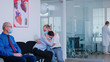 © DC Studio - Unfavorable news from doctor to young couple in hospital waiting area during corona virus outbreak. Husband and wife wearing face mask against infection with covid 19.