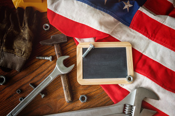 American National Holiday. US Flags with American stars, stripes and national colors. Construction and manufacturing tools on wooden background. Labor day background concept.