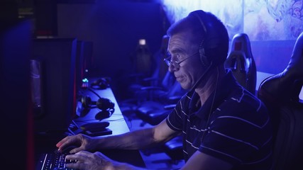 Old man gamer is emotionally playing and losing in a computer game