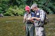 © goodluz - A father and his son fly fishing in summer on a beautiful trout river with clear water