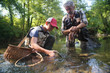 © goodluz - a father and his son fly fishing and catch a beautiful rainbow trout